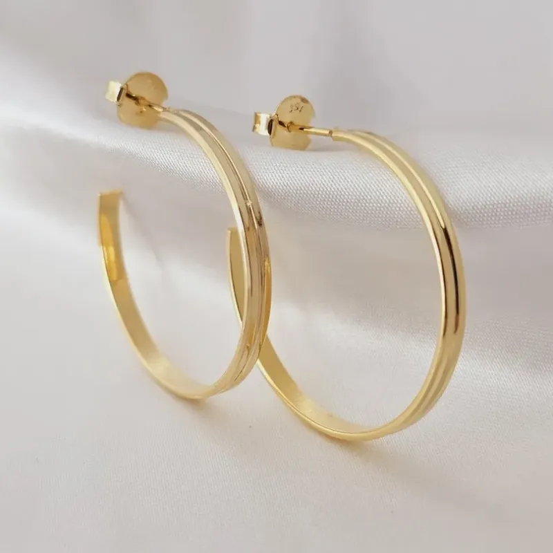 Argola retangular com friso no centro banhada a ouro