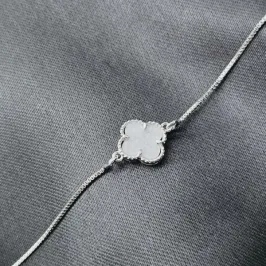 Pulseira com trevo marmorizado branco no meio, banhado a prata, medindo 28cm. Pulseira com trevo marmorizado branco no meio, banhado a prata, medindo 28cm.