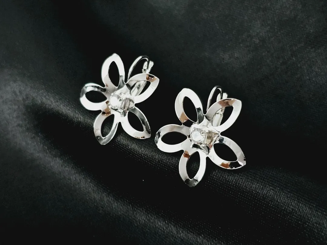 Brinco com flor de pétalas vazadas e zirconia ao centro banhado a prata