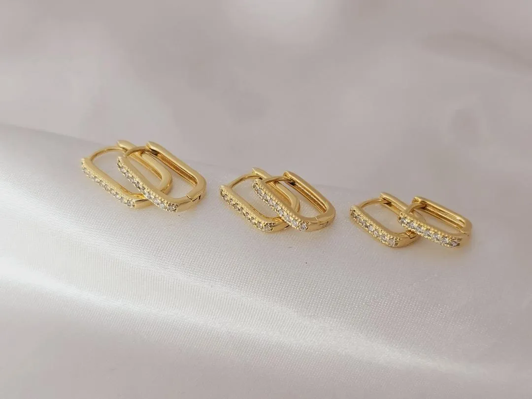 Trio de argolas retangulares cravejadas banhado a ouro, medindo (1,5cm; 1,4cm; 1cm)