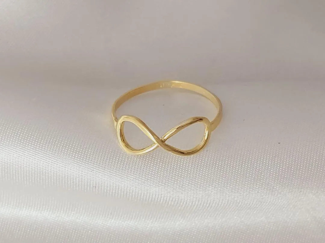 Anel simbolo do infinito, banhado a ouro, medindo 0,7cm de espessura