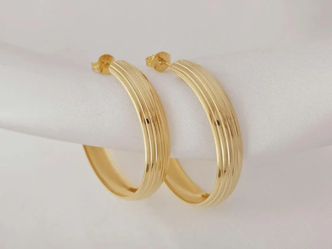 Argola com linhas verticais banhada a ouro, medindo 3,5x0,7cm