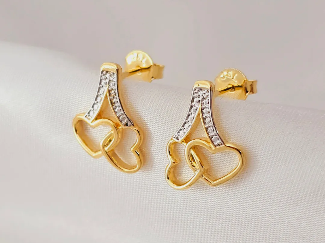 Brinco dois corações vazados em formato de cereja com detalhes em prata, medindo 3,0cm, banhado a ouro