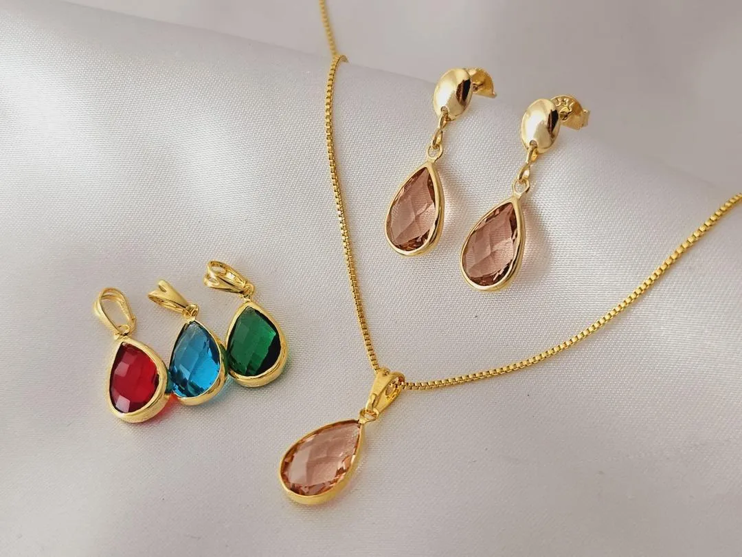 Conjunto de pingente e brincos de base oval e pedra colorida em formato de gota, medindo (2,3cm) banhado a ouro.