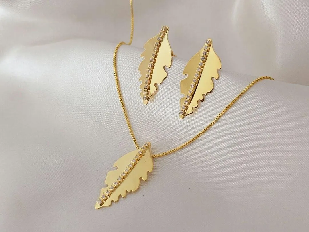 Conjunto folha com zirconia no centro, banhado a ouro pingente e brinco medindo 3,0x1,5cm