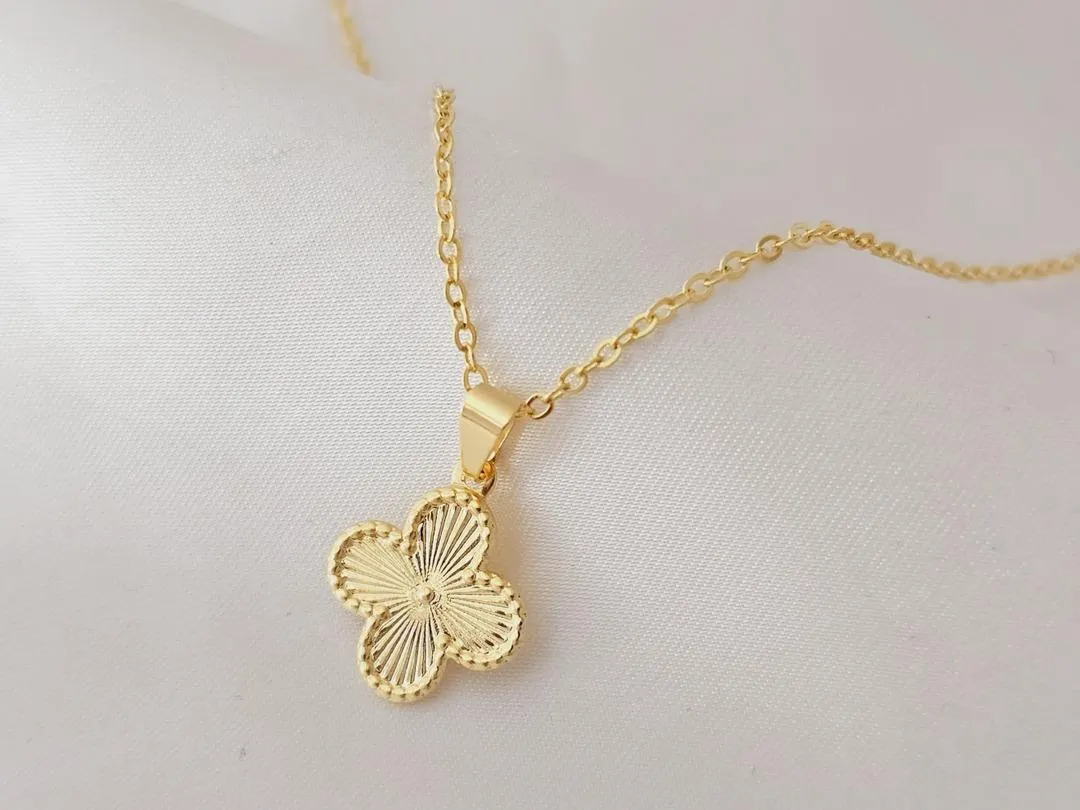 Gargantilha com pingente de trevo, banhado a ouro, medindo 45cm.