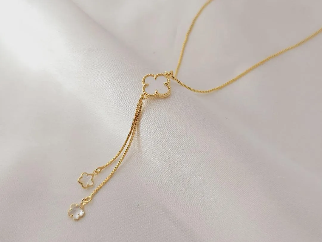 Gargantilha gravata com um trevo branco e dois fios com estrelas cristal na ponta, banhado a ouro, medindo 45cm + 6cm.