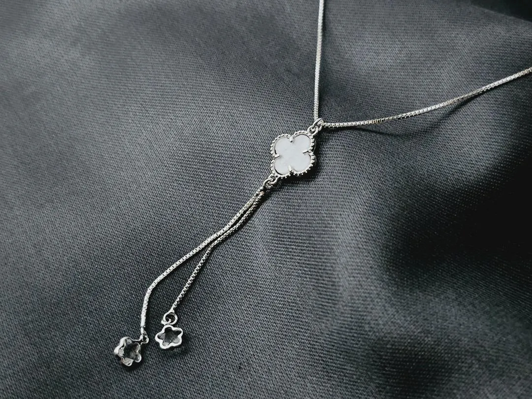 Gargantilha gravata com um trevo branco e dois fios com estrelas cristal na ponta banhado a prata, medindo 45cm + 6cm